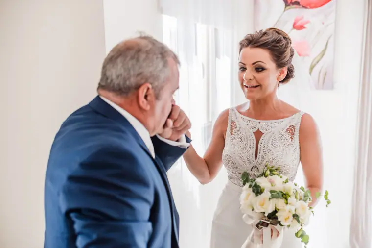Man in a navy suit overcome with emotion on seeing the bride in her gown