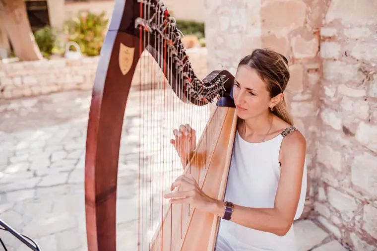 Harpist playing in the stone courtyard before the ceremony