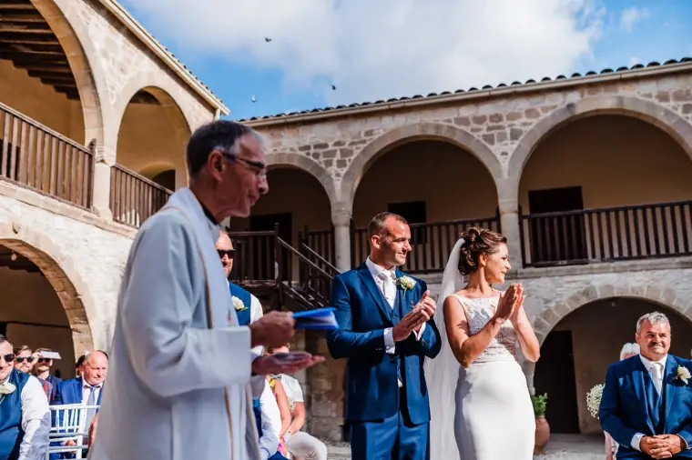 Priest leading the ceremony beneath the arched cloisters of the monastery