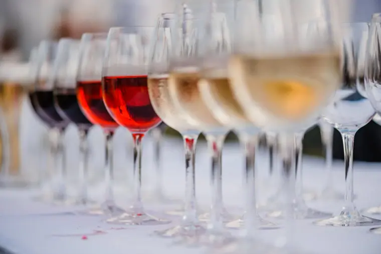 Row of red, rosé and white wine glasses lined up for the reception