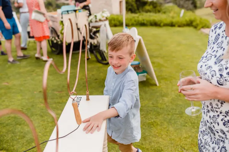 Young boy playing by a wooden board game on the reception lawn
