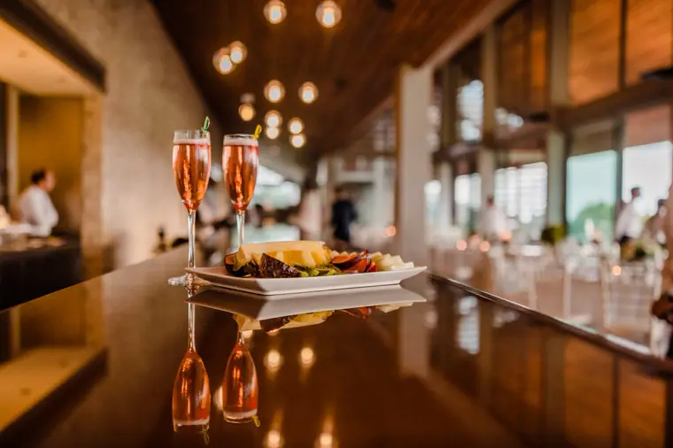 Glasses of rosé Champagne and canapés on the polished bar of the Minthis Hills restaurant