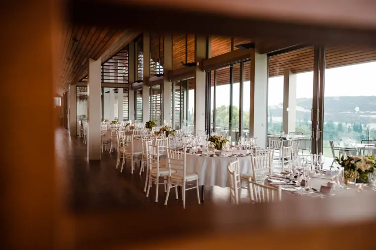 Reception room at Minthis Hills set with white chairs and floor-to-ceiling windows