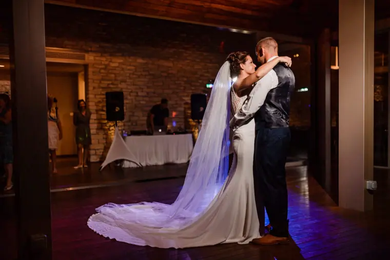 Bride and groom's first dance, her long veil trailing across the floor
