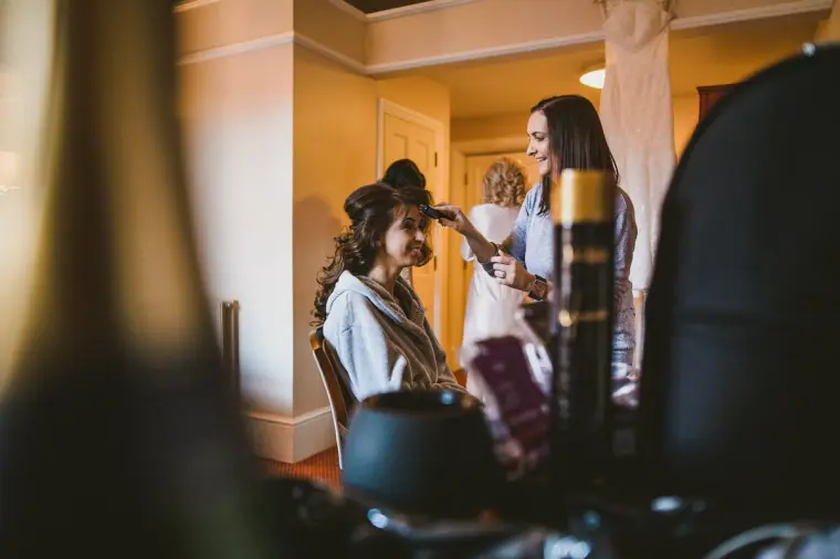 Bridal preparations in a hotel suite, glimpsed past styling products in the foreground