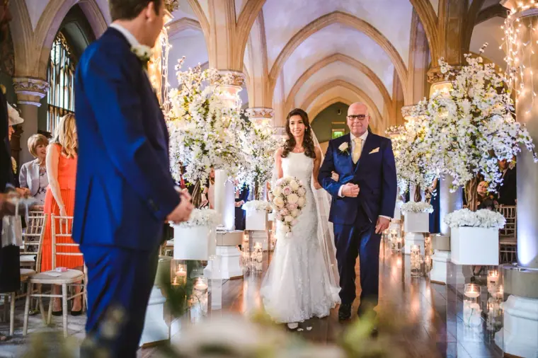 Elina walking down the aisle on her father's arm towards Iain