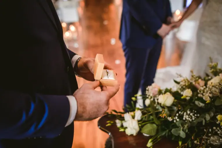 Groomsman opening a ring box during the ceremony