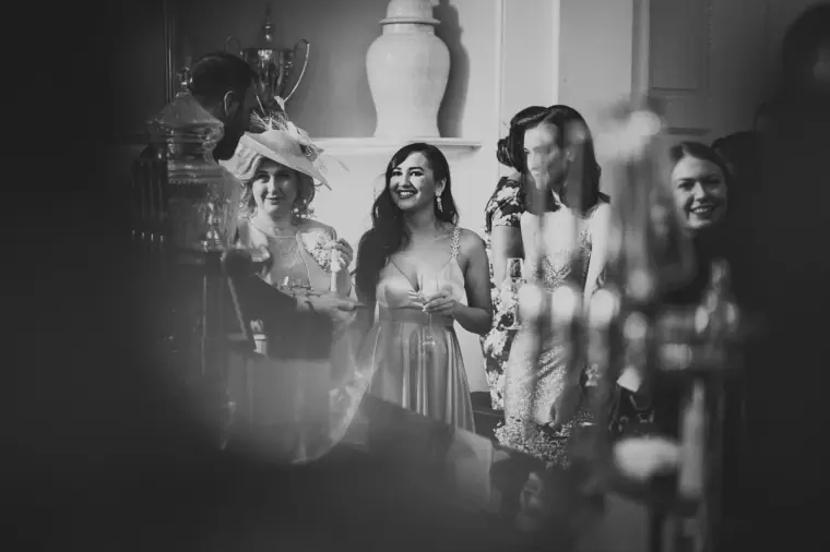 Black-and-white photo of bridesmaids and guests laughing together