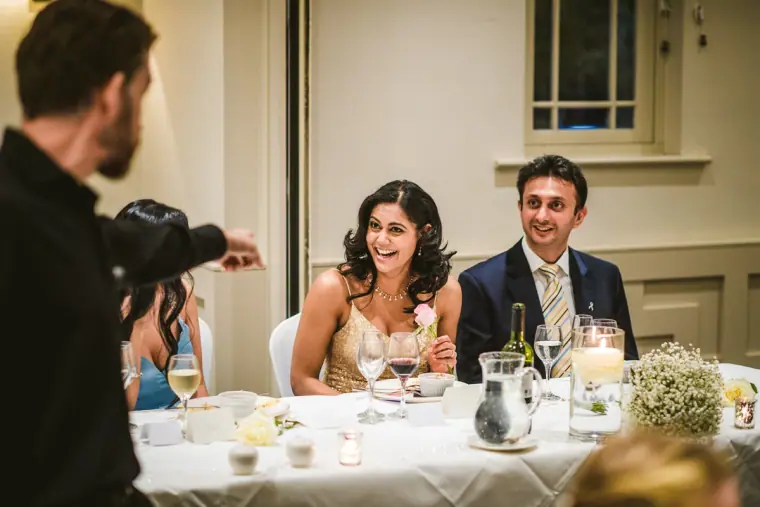 Guests laughing at the singing waiters' surprise performance at their table