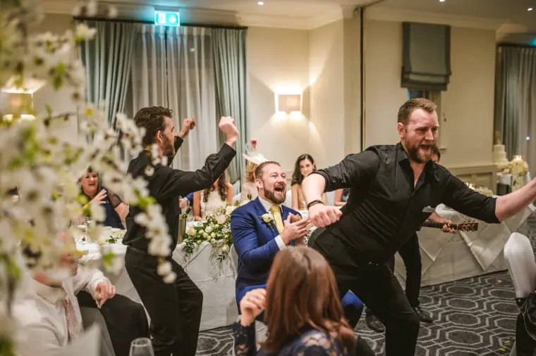 Singing waiters dancing between tables as guests cheer