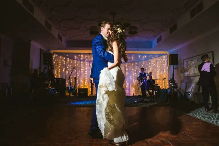 Elina and Iain dancing in front of the band and fairy-light curtain at Wotton House