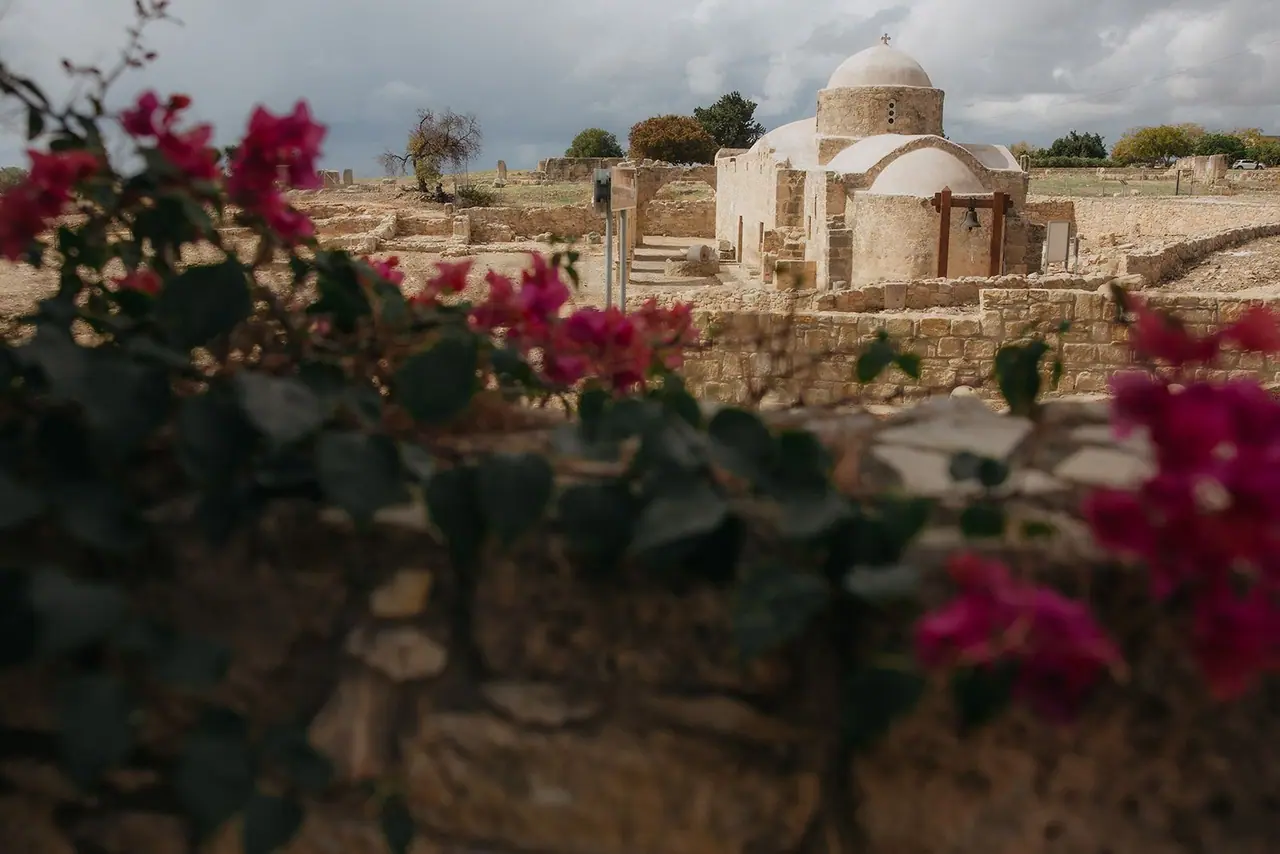 Panagia Katholiki church seen across the Palaepaphos ruins through pink bougainvillea from Liopetro, Kouklia