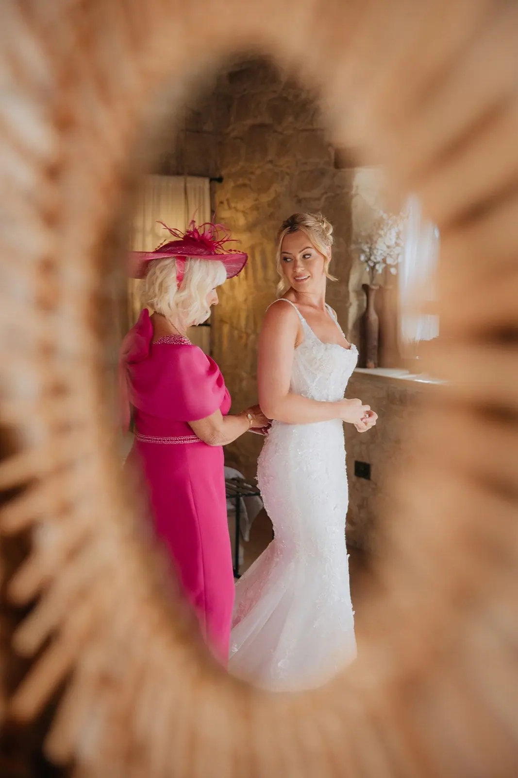 Zoe and her mum framed in a round rattan mirror in the bridal suite