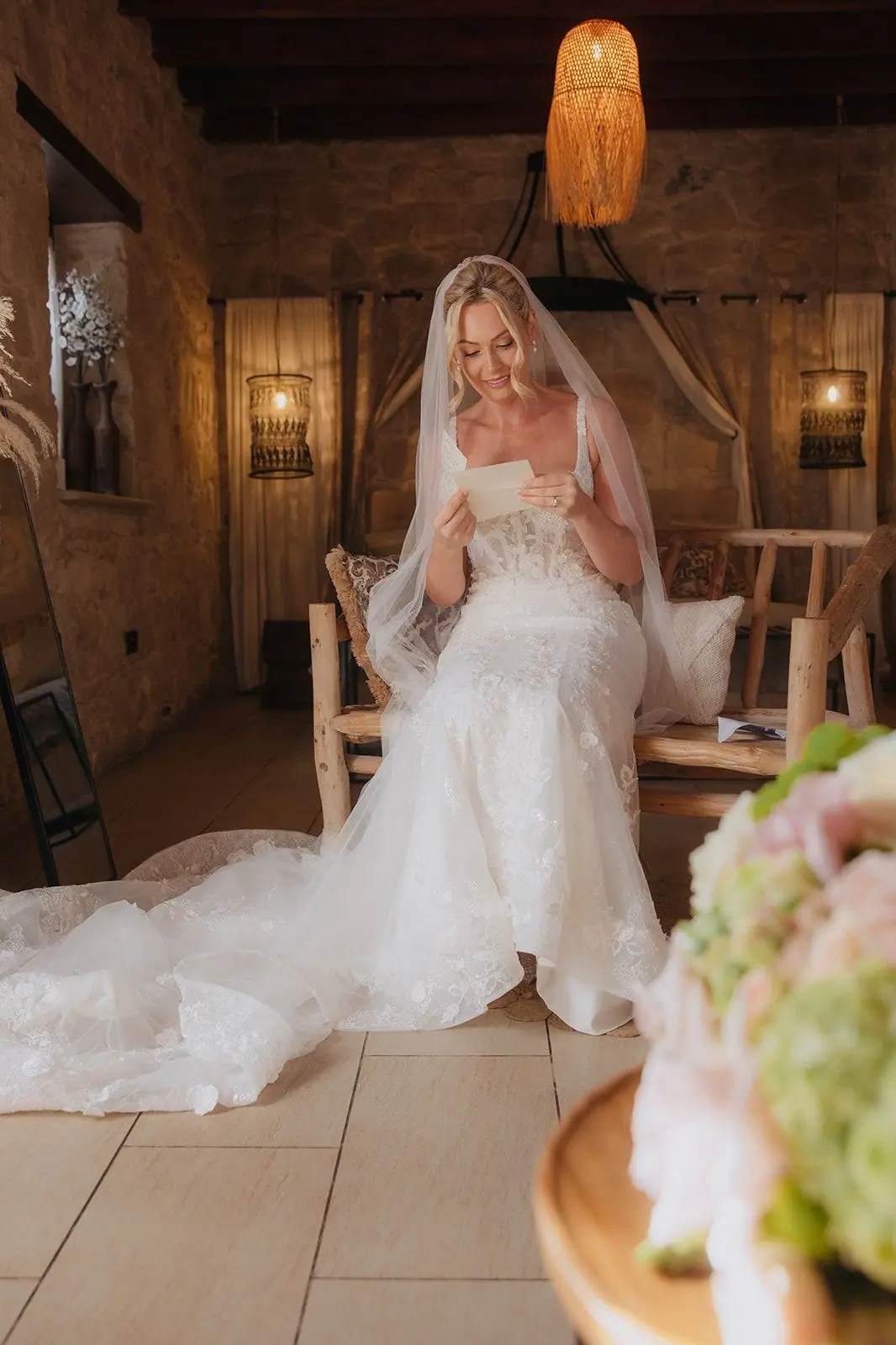 Zoe in her wedding dress reading a letter, her train spread across the floor