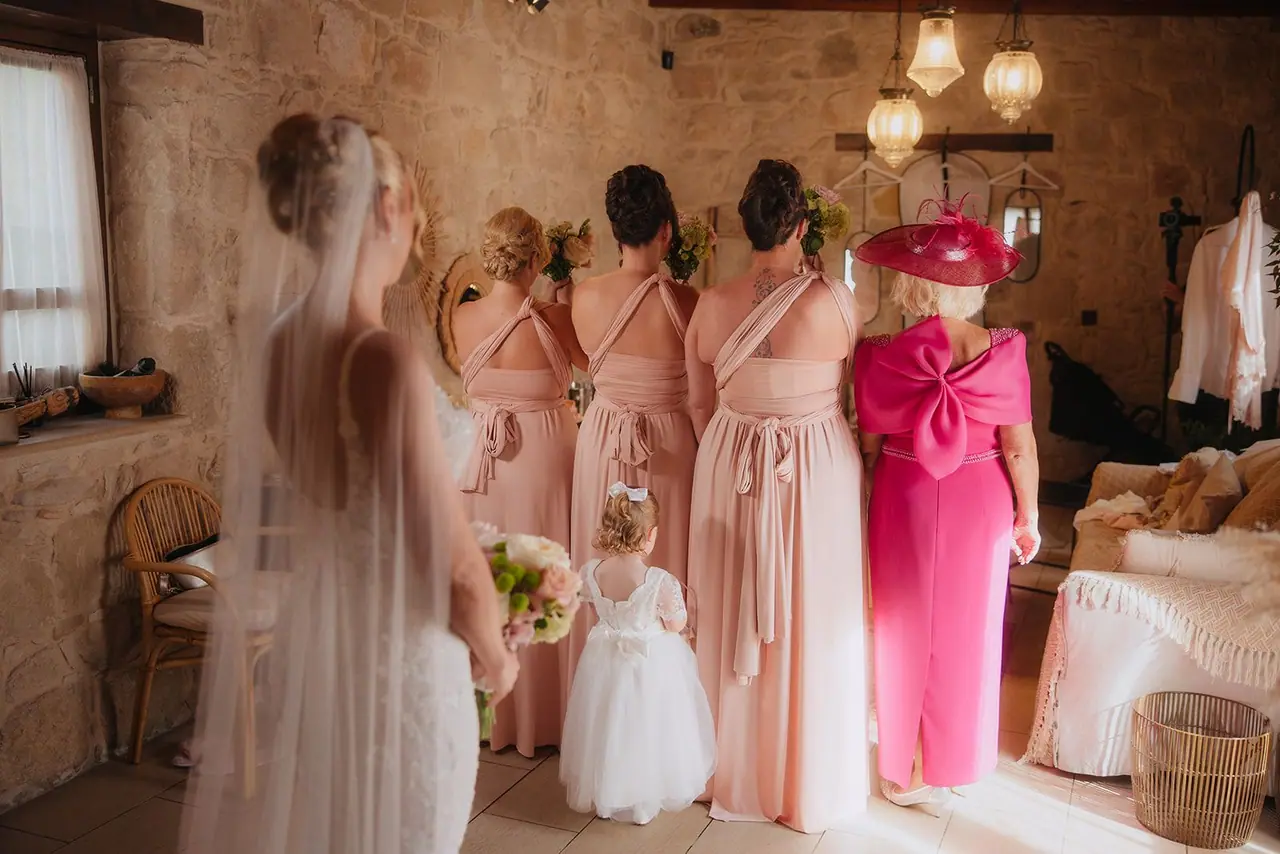 Bridesmaids, Zoe's mum and her daughter waiting with their backs turned as Zoe steps in behind them