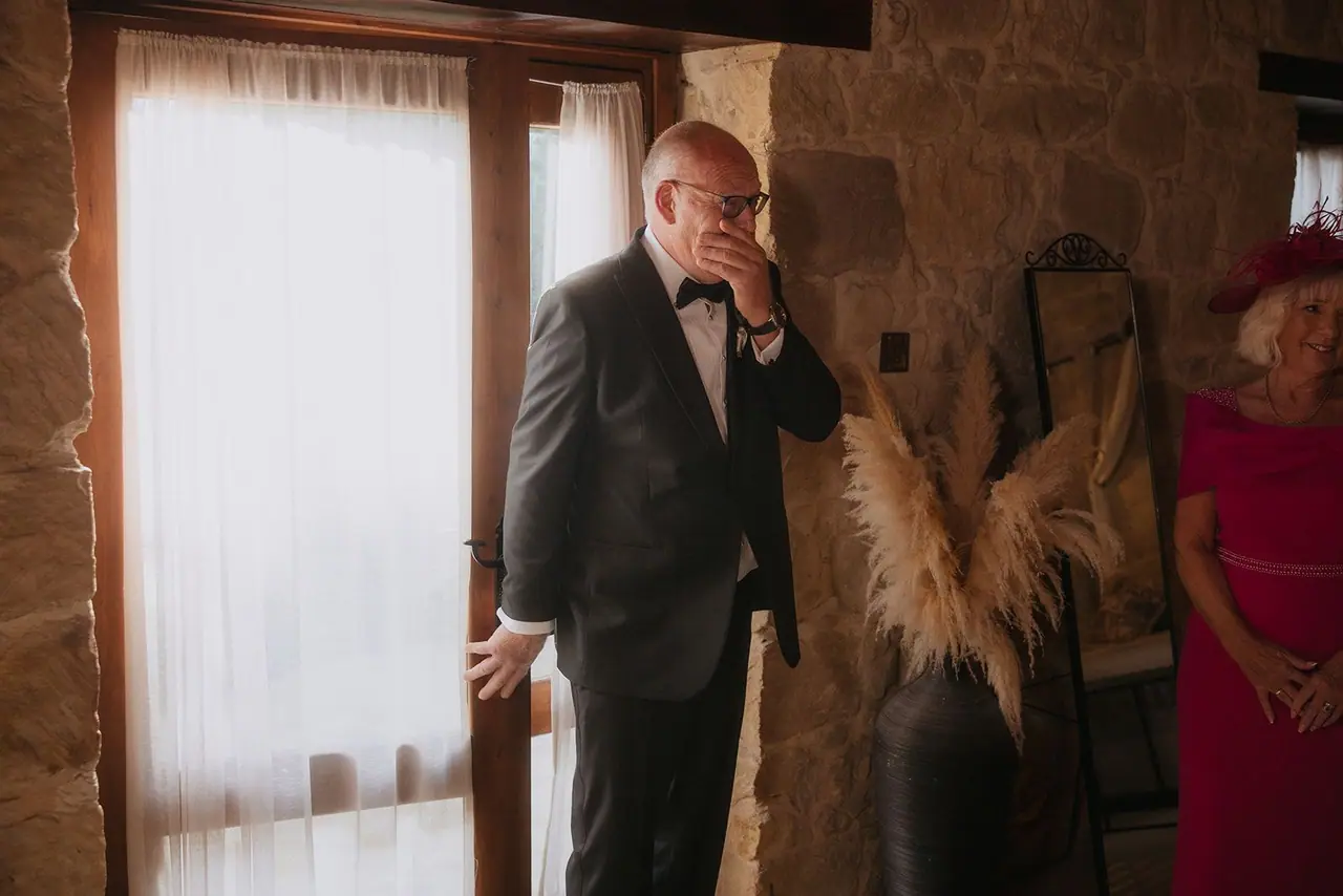 Zoe's dad wiping away a tear in the doorway as he sees her in her wedding dress