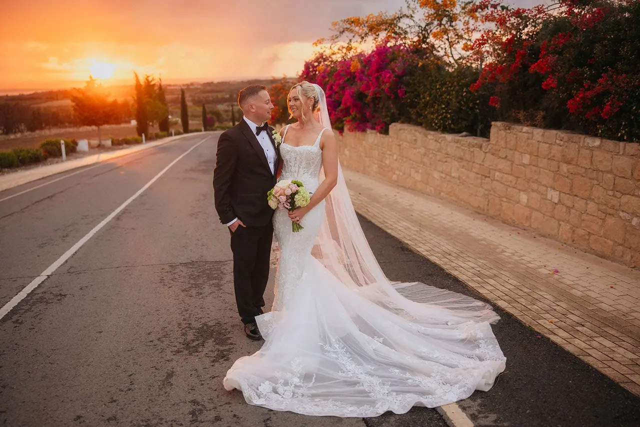 Zoe and Oliver on the Kouklia road at golden hour, bougainvillea and sunset behind them