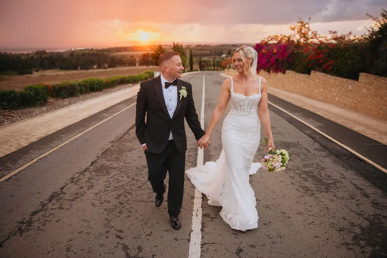 Zoe and Oliver walking hand in hand up the road towards Liopetro at dusk