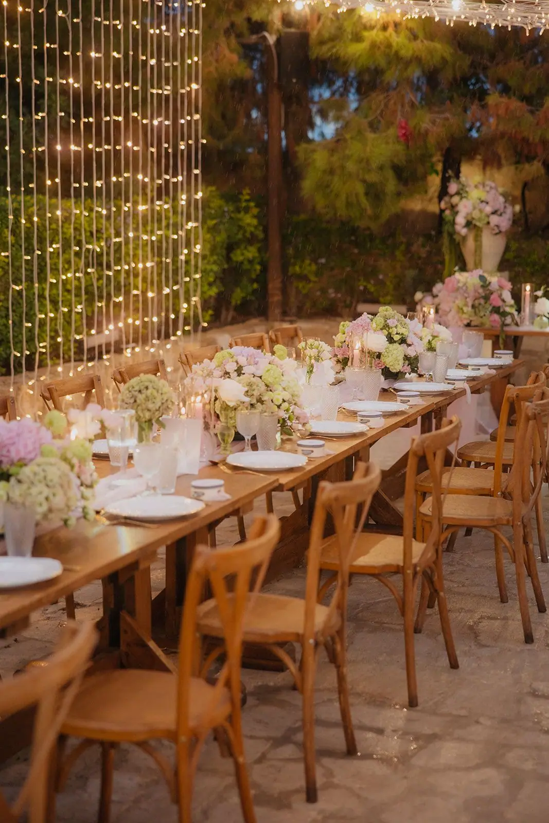 Reception tables beneath a wall of fairy lights