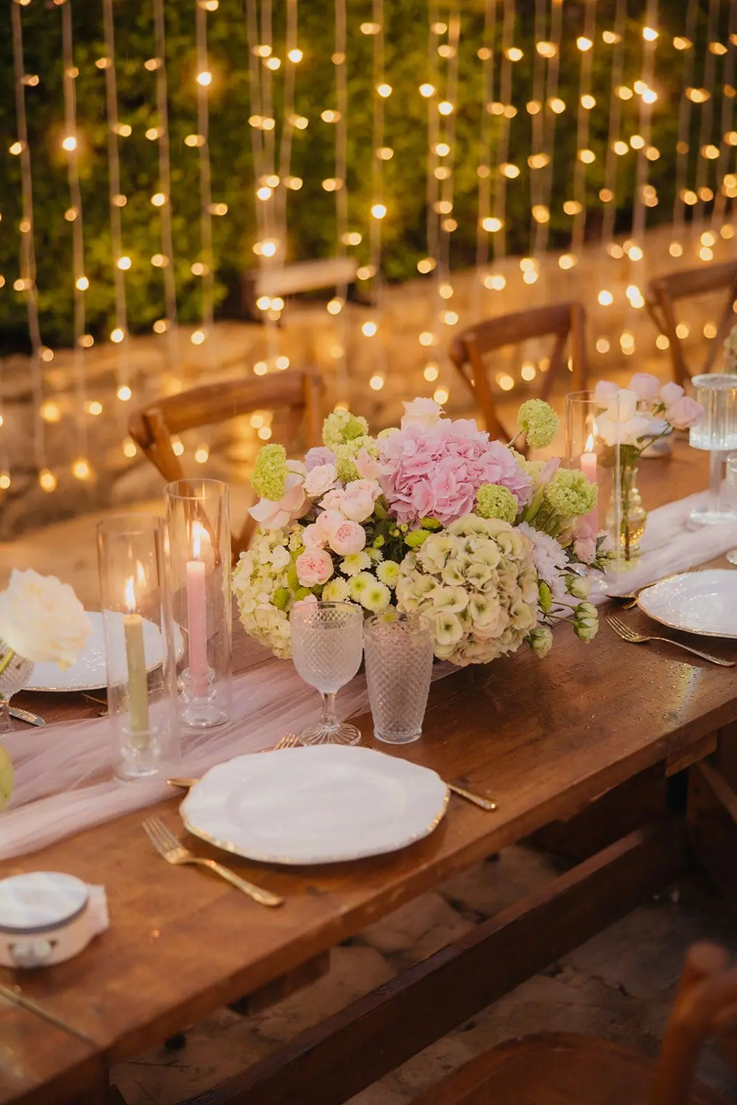 Hydrangea centrepiece and candles on a wooden reception table