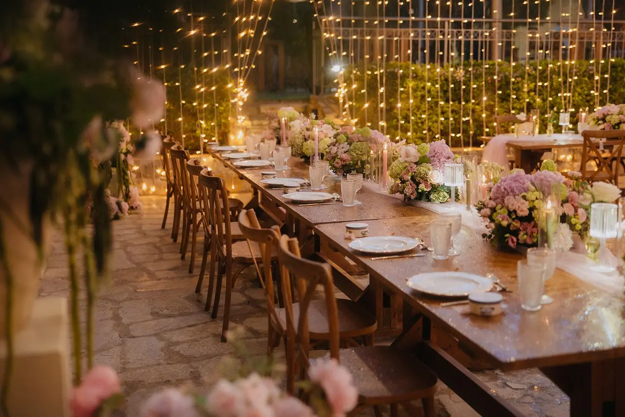 Reception tables and flowers glowing under the fairy lights