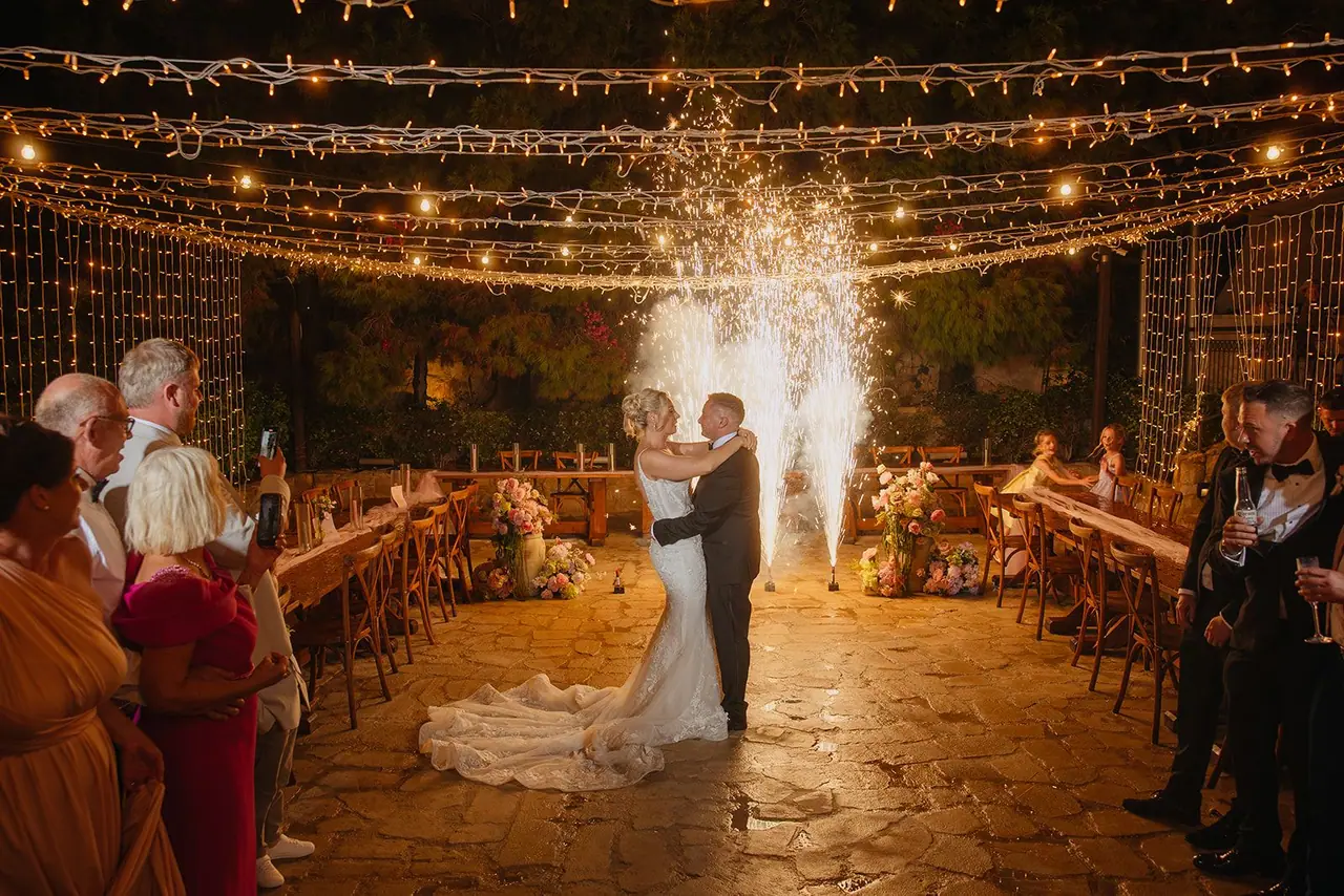 Zoe and Oliver's first dance as cold sparks rise behind them under the fairy lights