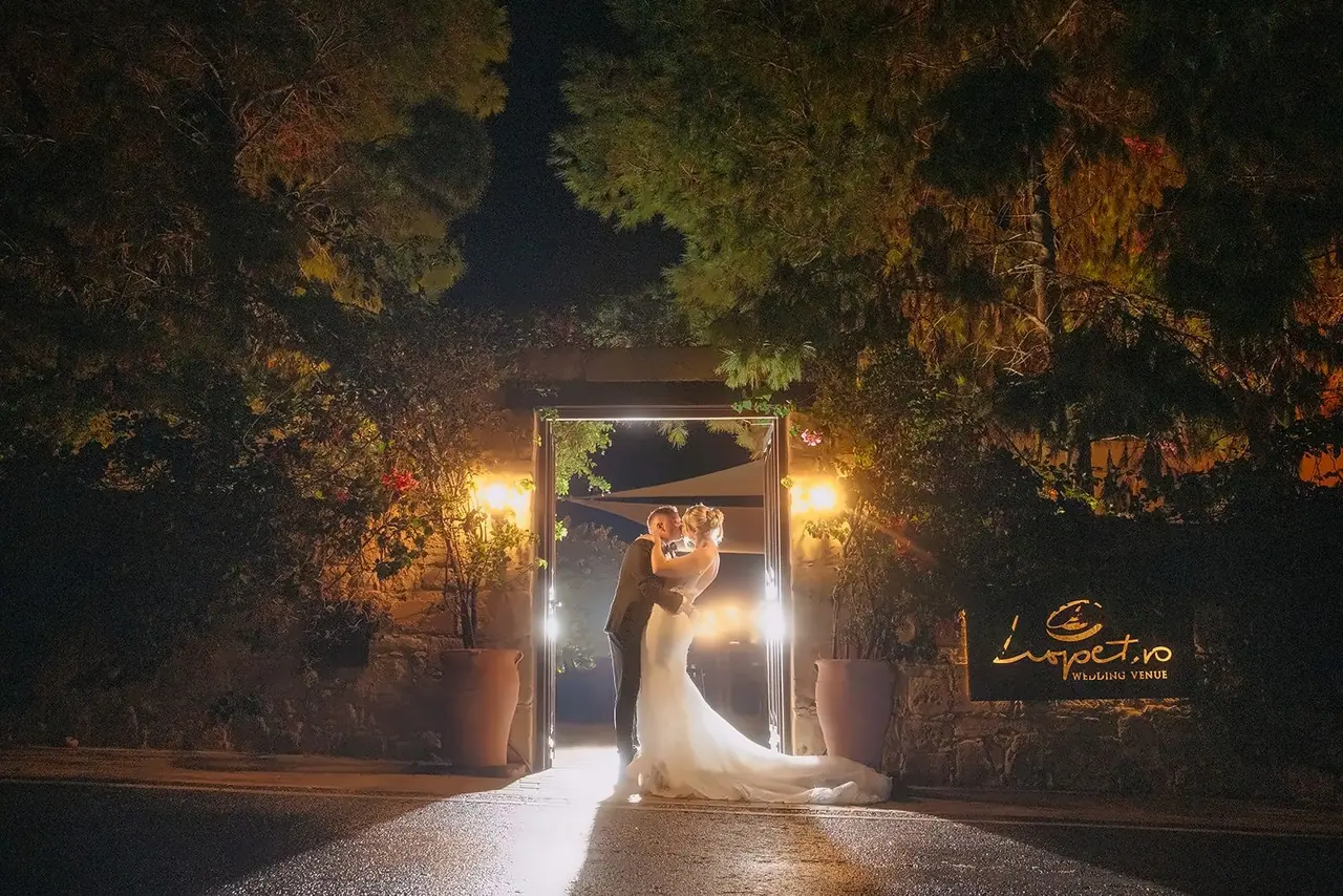 Zoe and Oliver kissing in Liopetro's lit doorway at night
