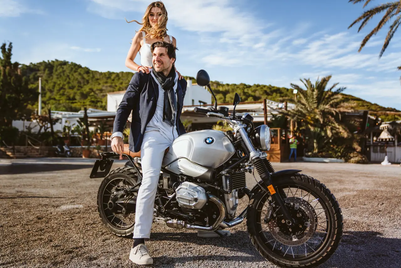 Birger on a motorbike as Antonia stands on the back, arms raised, Restaurante La Escollera, Ibiza