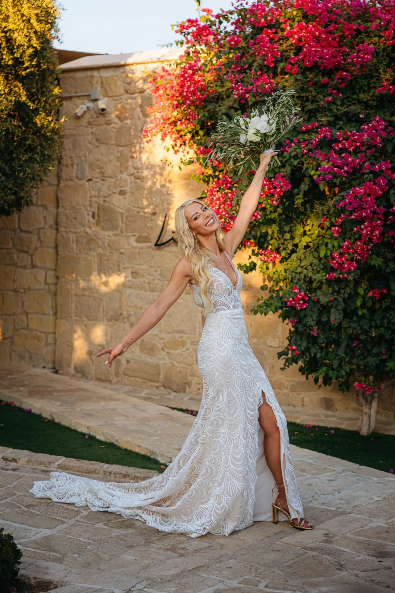 Emma posing with one arm raised beneath pink bougainvillea at Liopetro, Kouklia