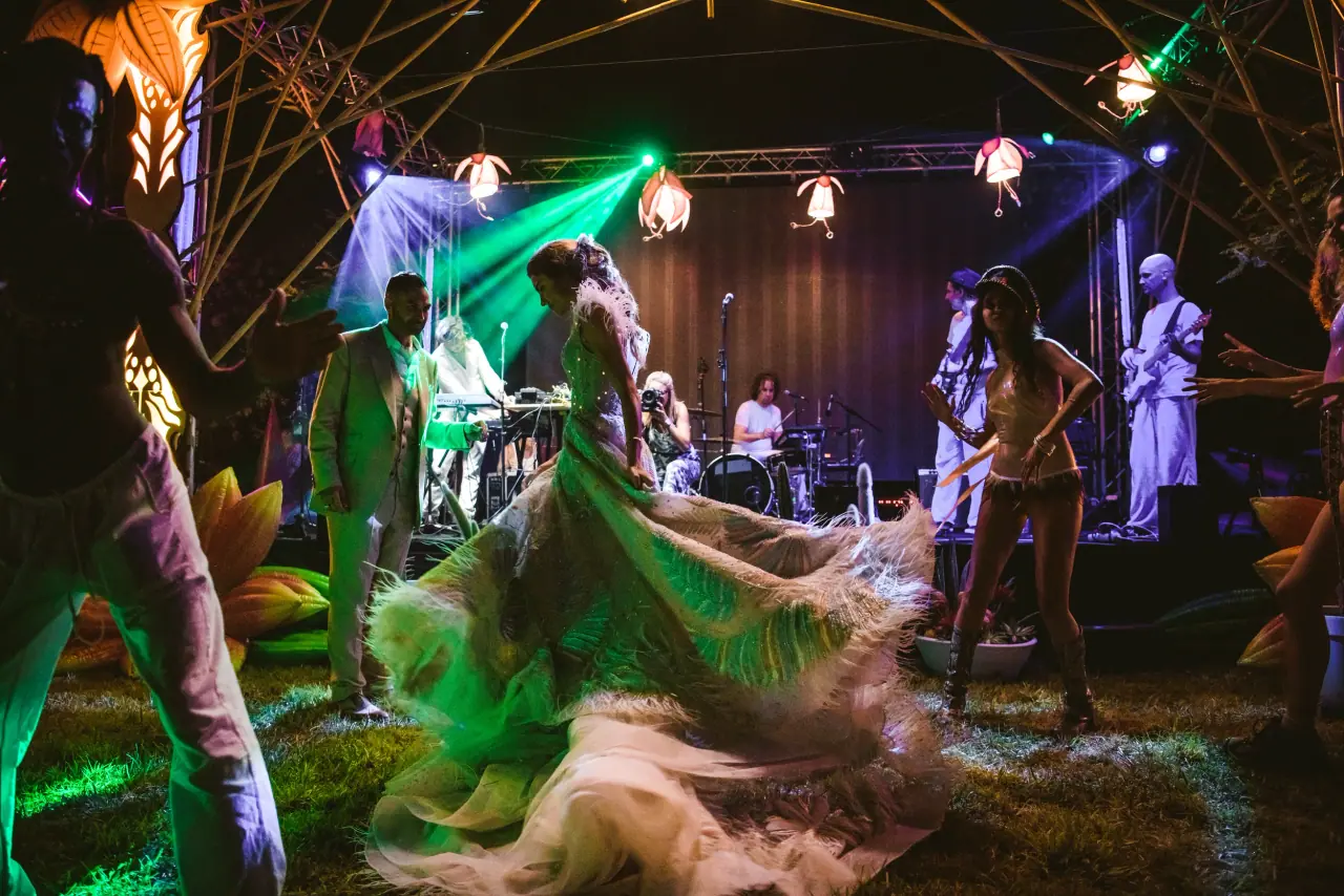 Bride twirling her dress on the dancefloor before a band stage lit in green