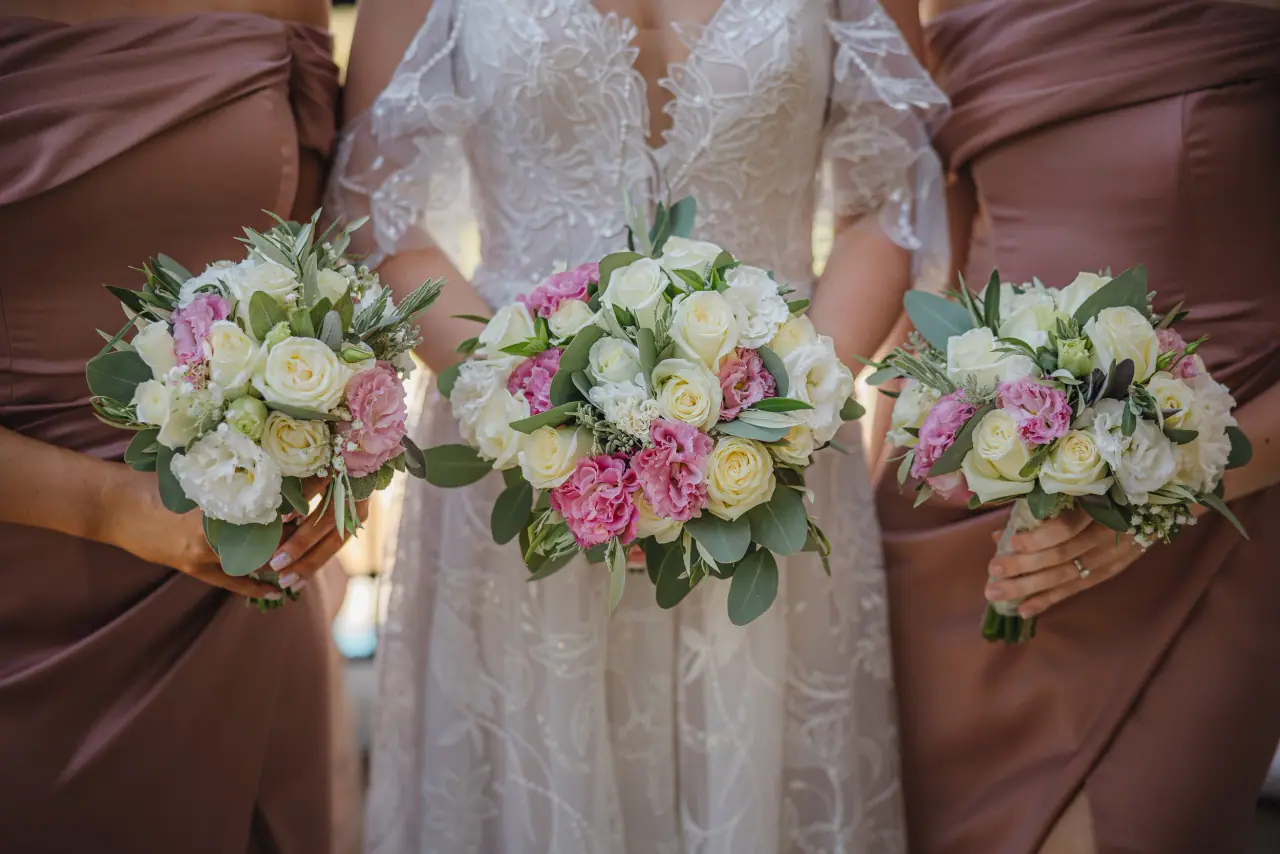 Bride and bridesmaids holding white and pink rose bouquets, Aphrodite Hills