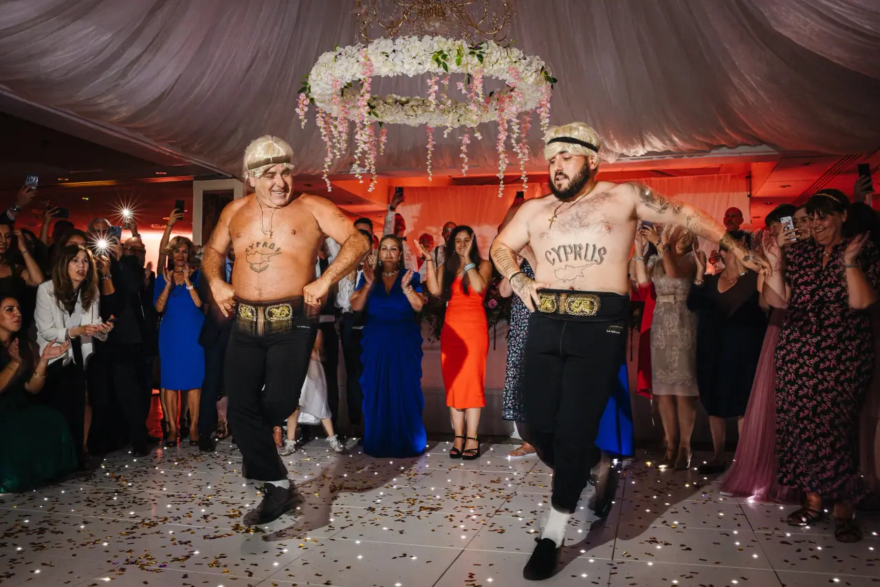 Shirtless men in headbands entertaining cheering guests on the dancefloor