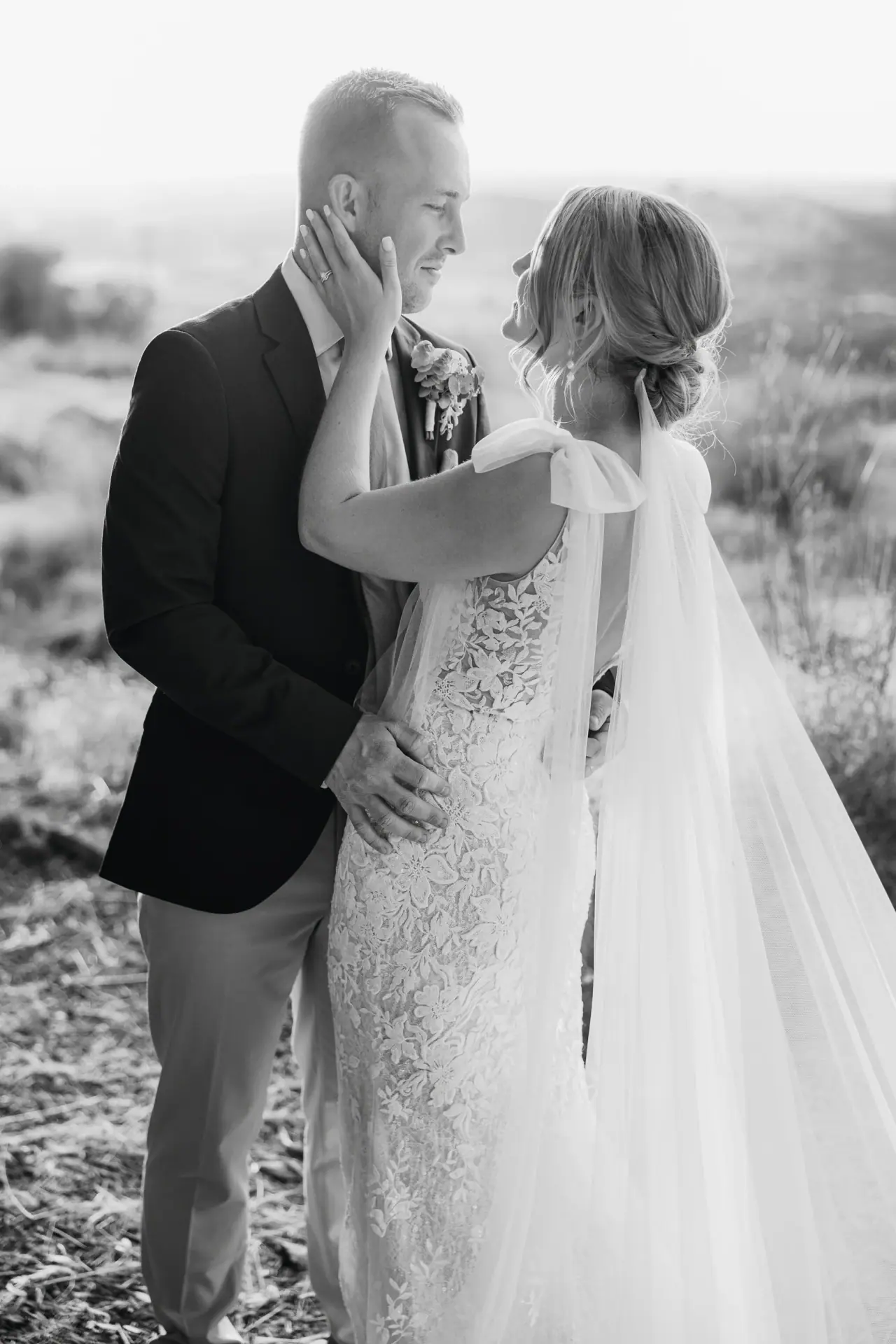 Black-and-white photo of Beth holding Josh's face as they lean in for a kiss
