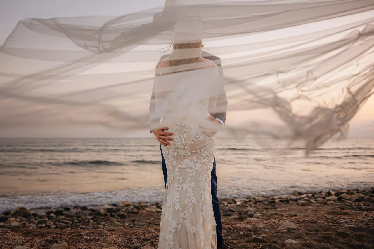 Sammi's veil blowing across her on the beach at sunset, Coral Residence