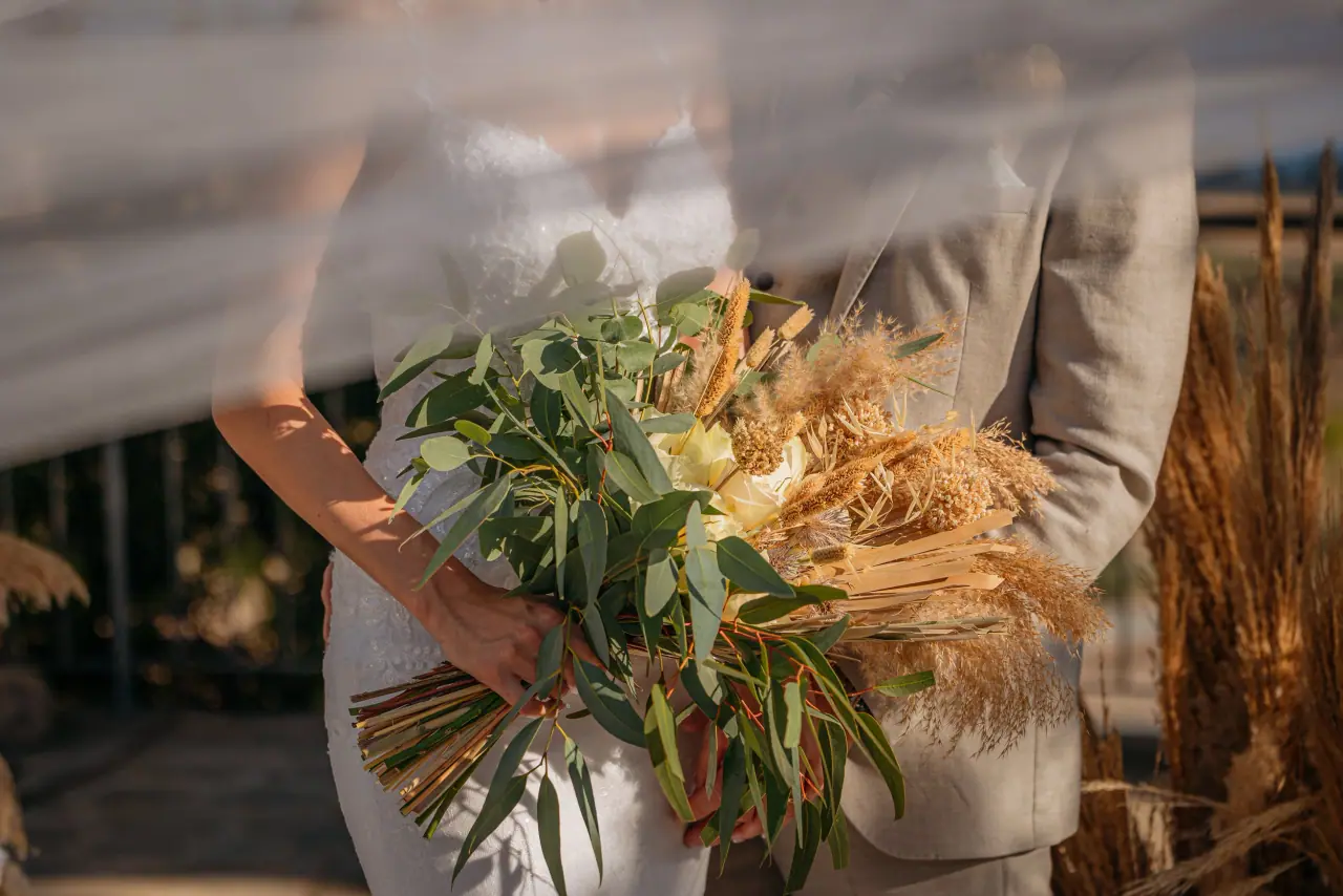 Close-up of Abby's dried-flower and greenery bouquet with Blair behind her