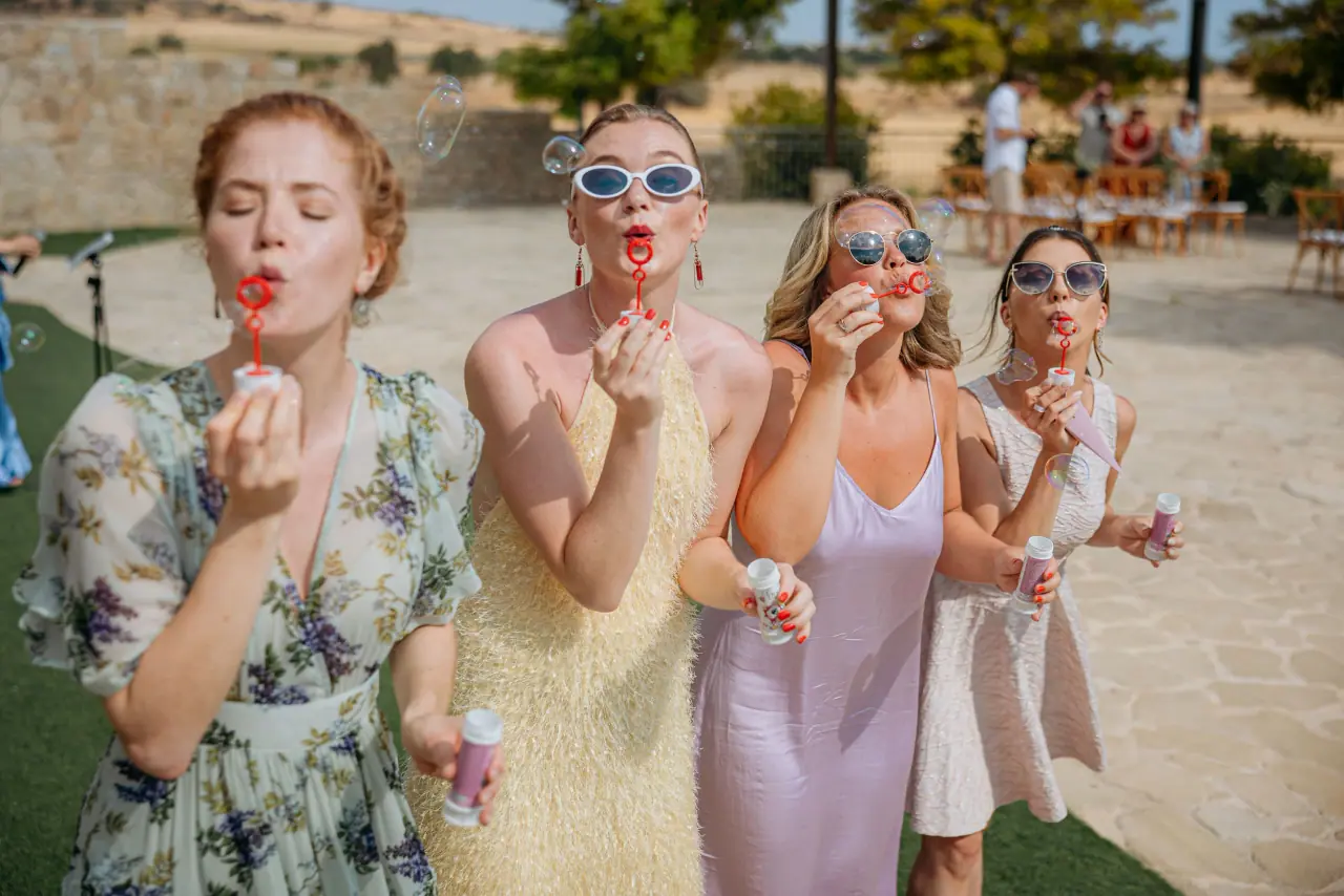Bridesmaids in sunglasses blowing bubbles at Vanja and Simon's wedding, Liopetro