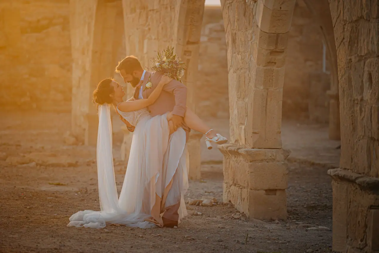Vanja and Simon kissing among stone arches at golden hour, Liopetro
