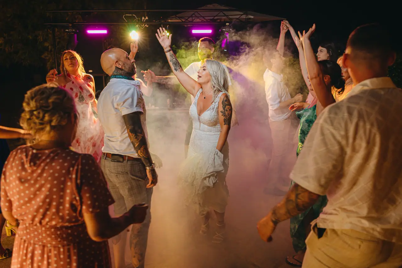 Gemma dancing amid haze and coloured lights with guests at Liopetro
