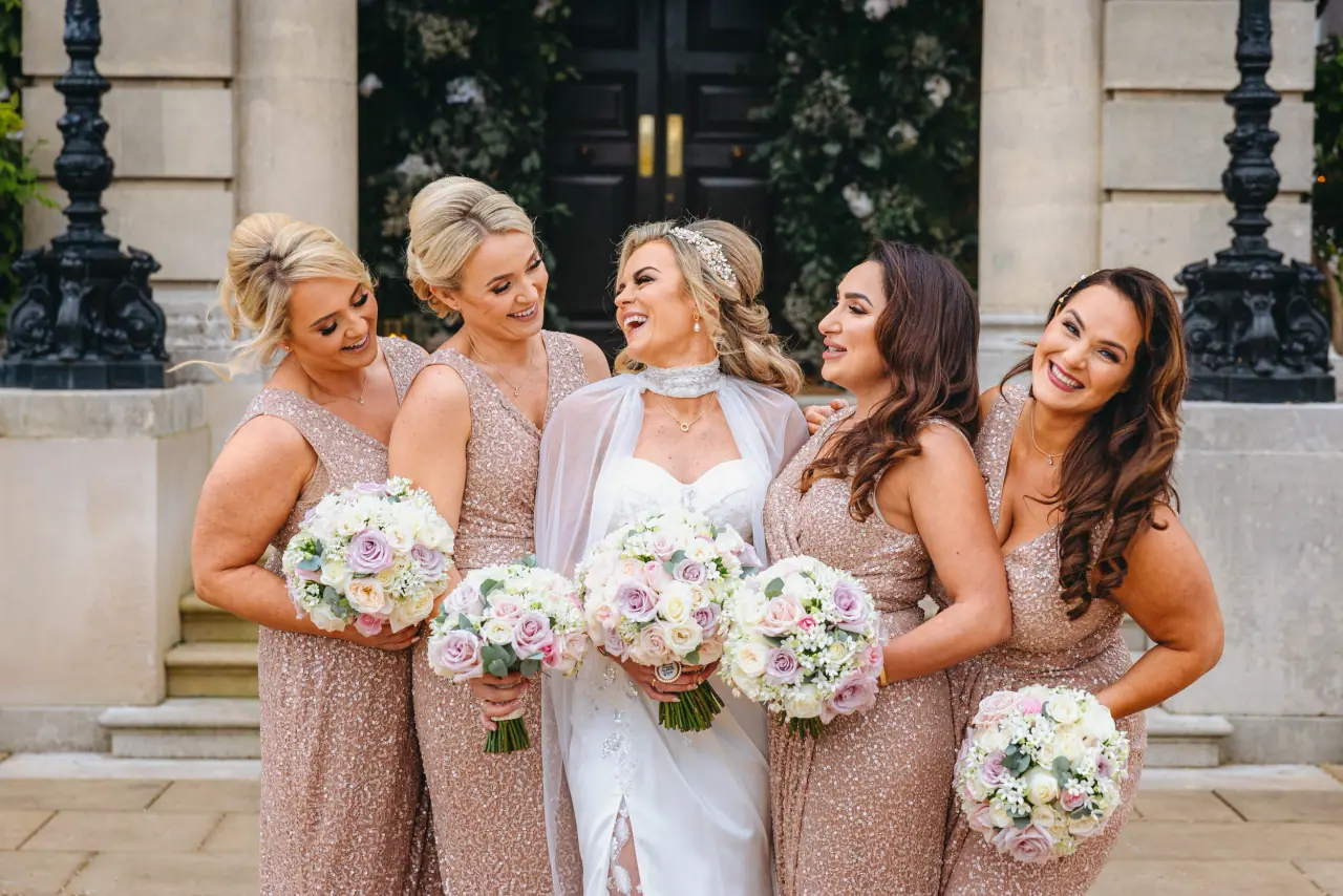 Jade laughing with bridesmaids in blush sequinned dresses at Hedsor House