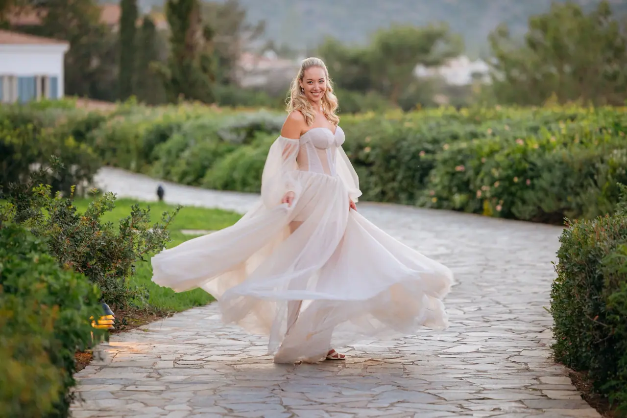 Jade's skirt swirling as she spins between hedges at Anassa