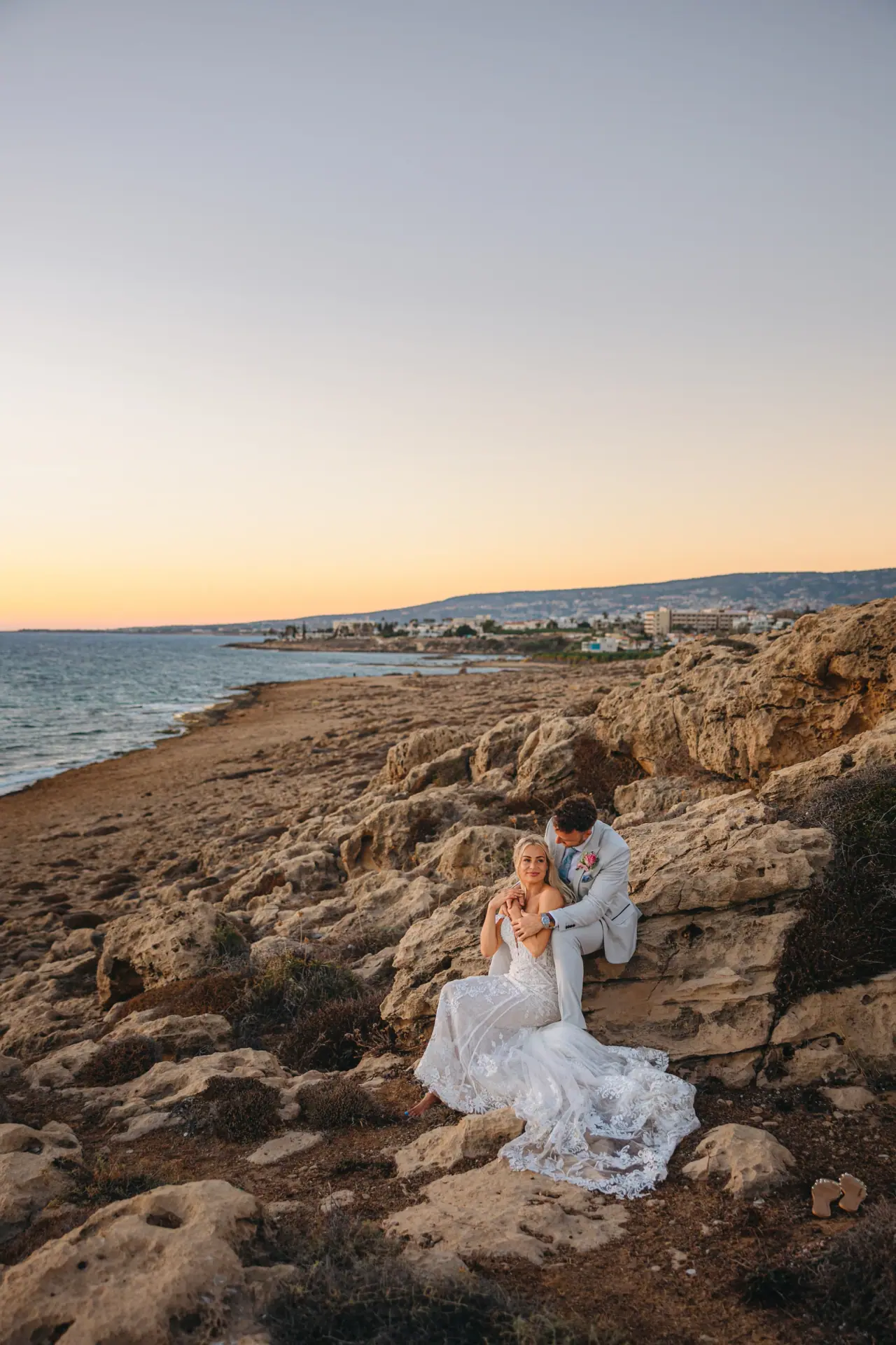 Jayley and Nick on rocks above the coastline at sunset