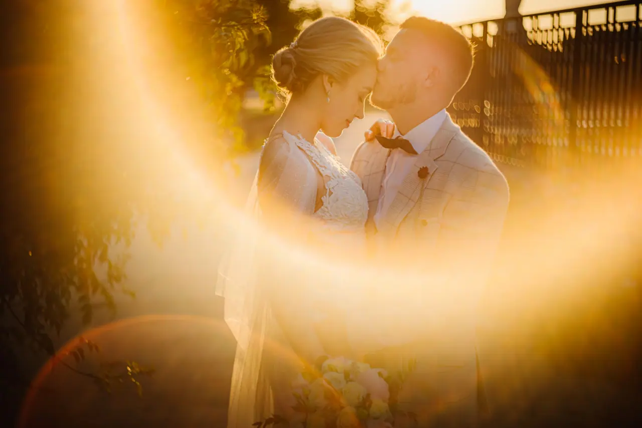 Mabel and James touching heads amid golden lens flare at Aphrodite Hills