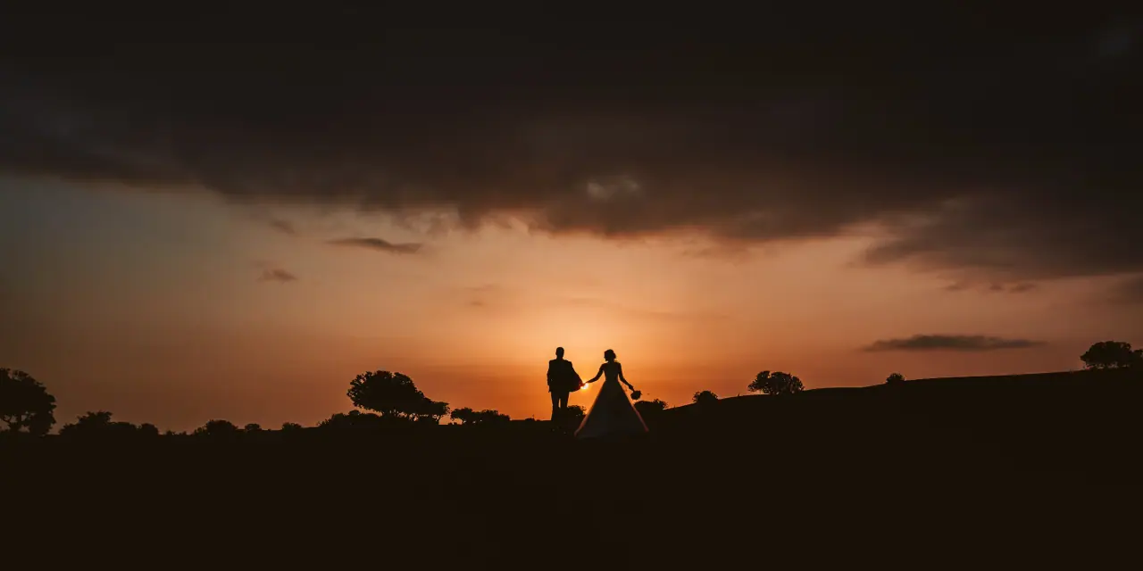 Lena and Chris silhouetted under dark clouds at sunset, Elea, Paphos