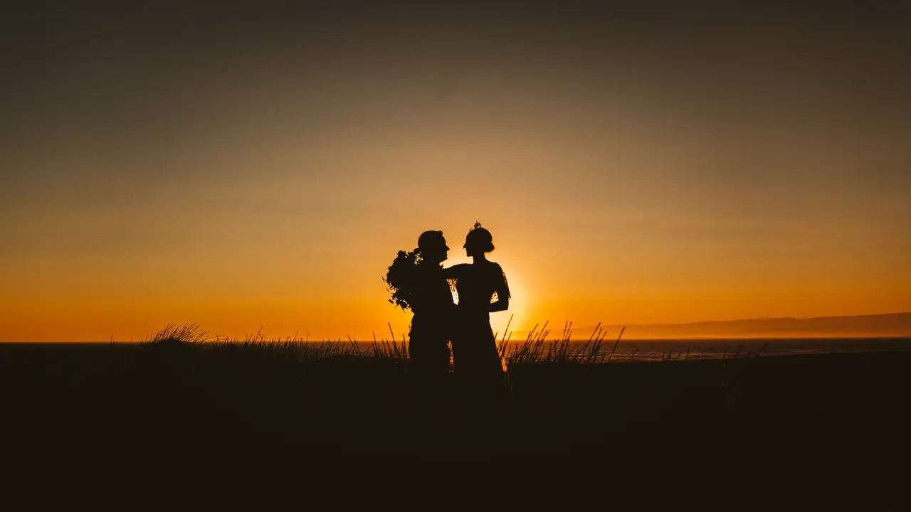 Madara and Gavin silhouetted against an orange sunset sky, Limassol