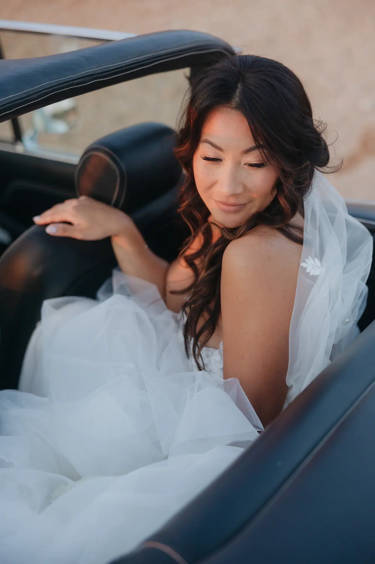 Bride seated in the back of the Triumph Stag at golden hour