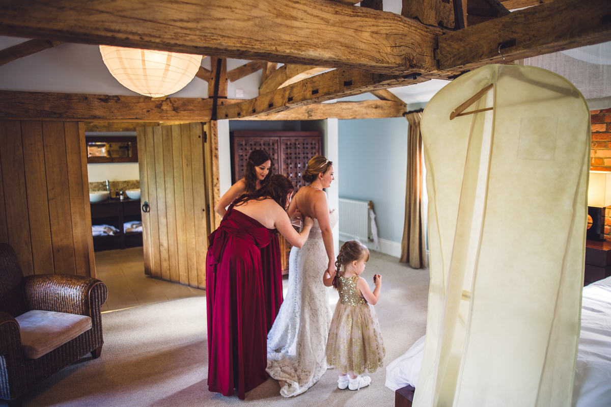 bridesmaids help the bride with dress
