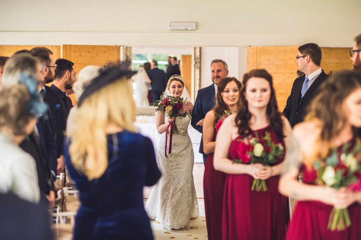 father and daughter walk to groom