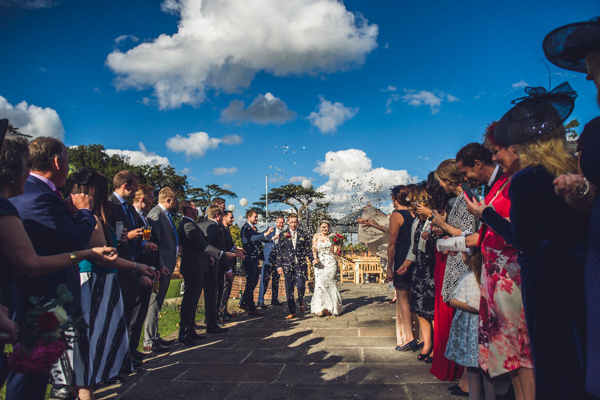 the bride and groom with guests throwing confetti